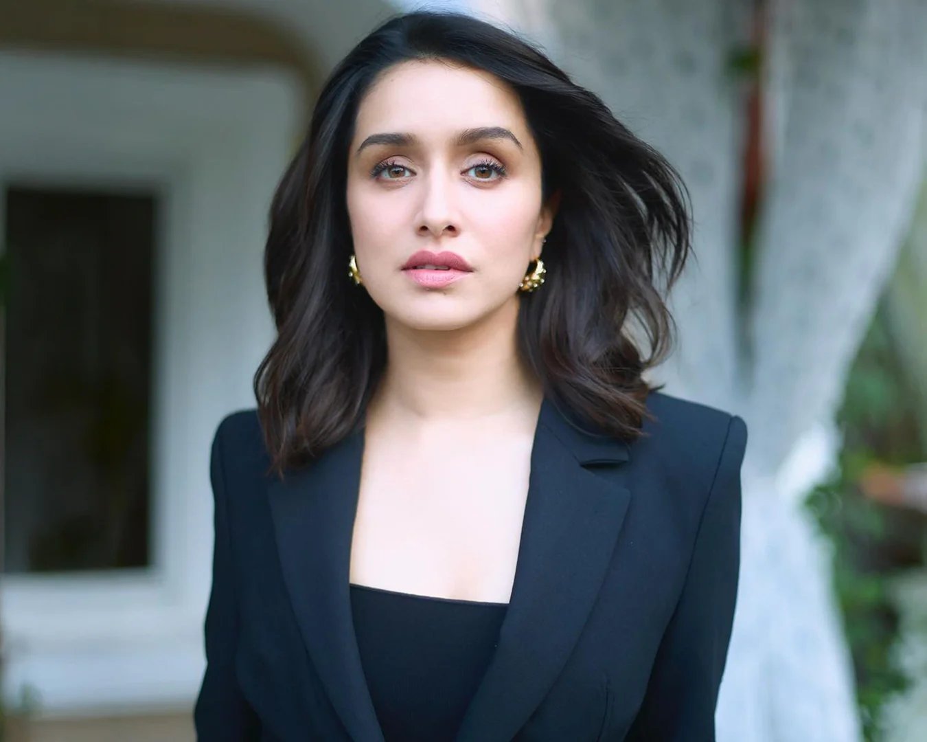 Shraddha Kapoor wearing gold hoop earrings and a black blazer